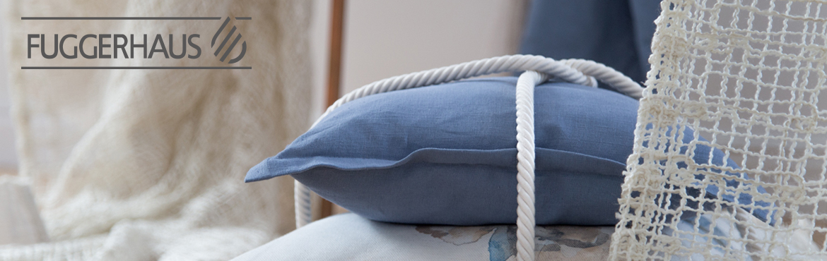 Een blauw kussen op een bed met een touw eraan.